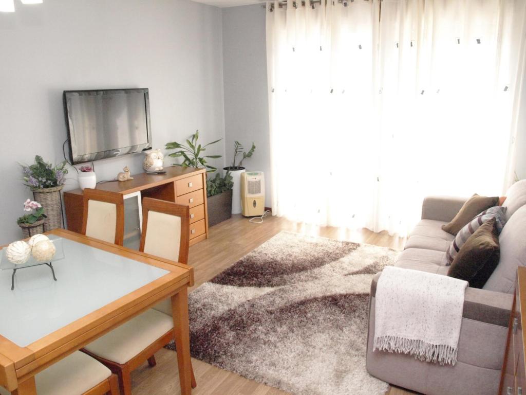 a living room with a couch and a tv at EPS53 T1,luminoso apartamento, 800m praia Apulia in Apúlia