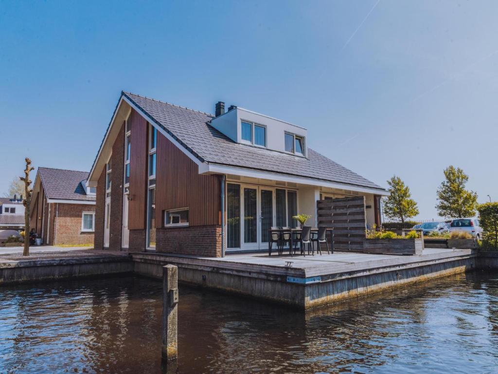a house on a dock next to a body of water at Dorregeest in Uitgeest