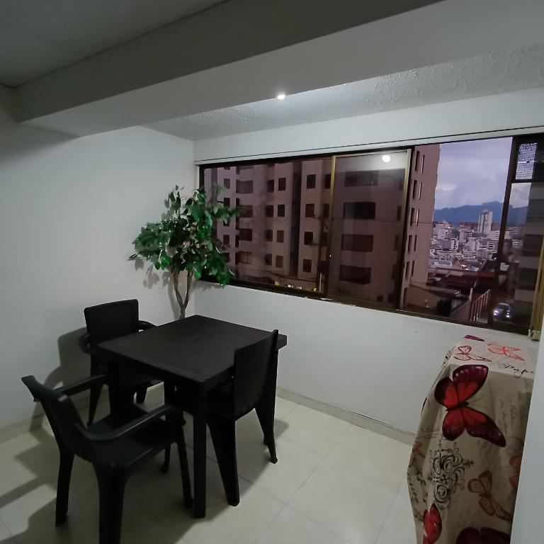 ein Esszimmer mit Tisch und Stühlen und einem Fenster in der Unterkunft Quédate En El Punto Más Central De Manizales in Manizales