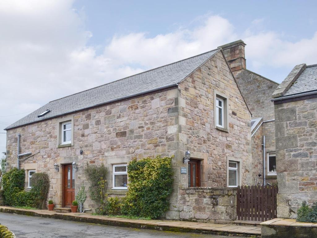 an old stone house with a black roof at Ferguson in Warenford
