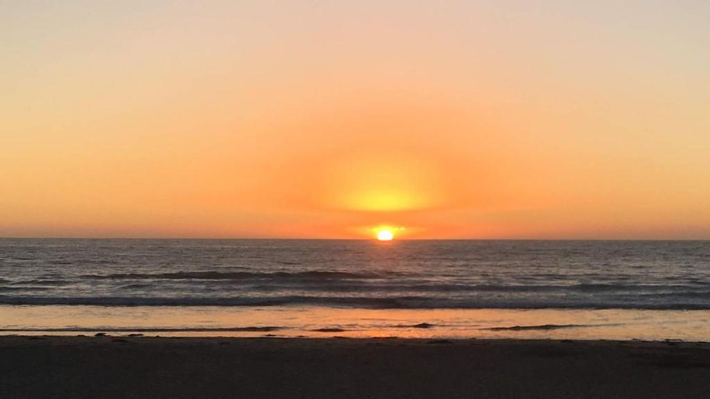 a sunset on the beach with the ocean at Departamento B84 in Puchuncaví