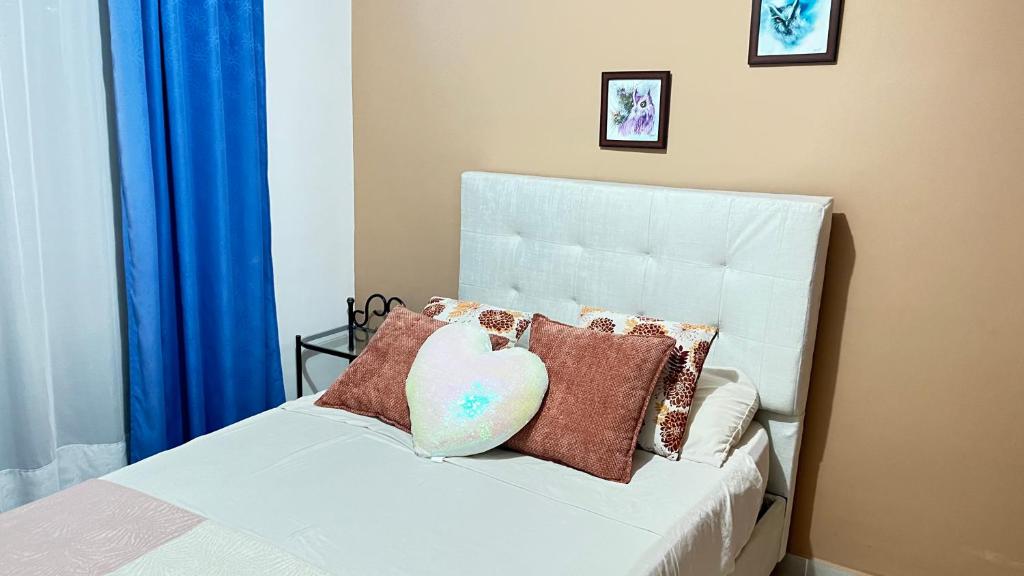 a bed with pillows and a heart pillow on it at Habitación dentro de un Apartamento compartido in Ibagué
