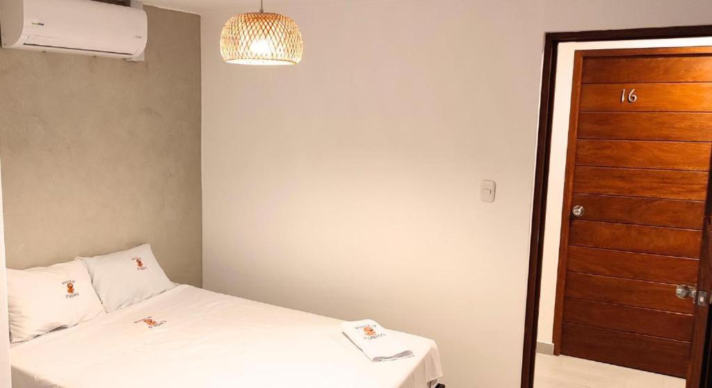 a small room with a bed and a wooden door at Los Pulpos in Bombiso