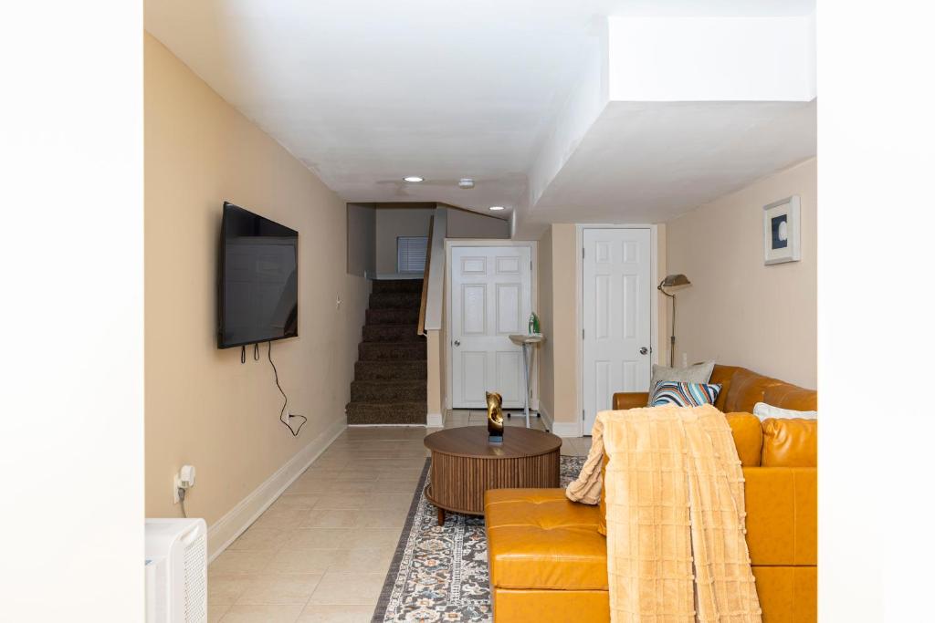 a living room with a yellow couch and a tv at CityStay in Baltimore