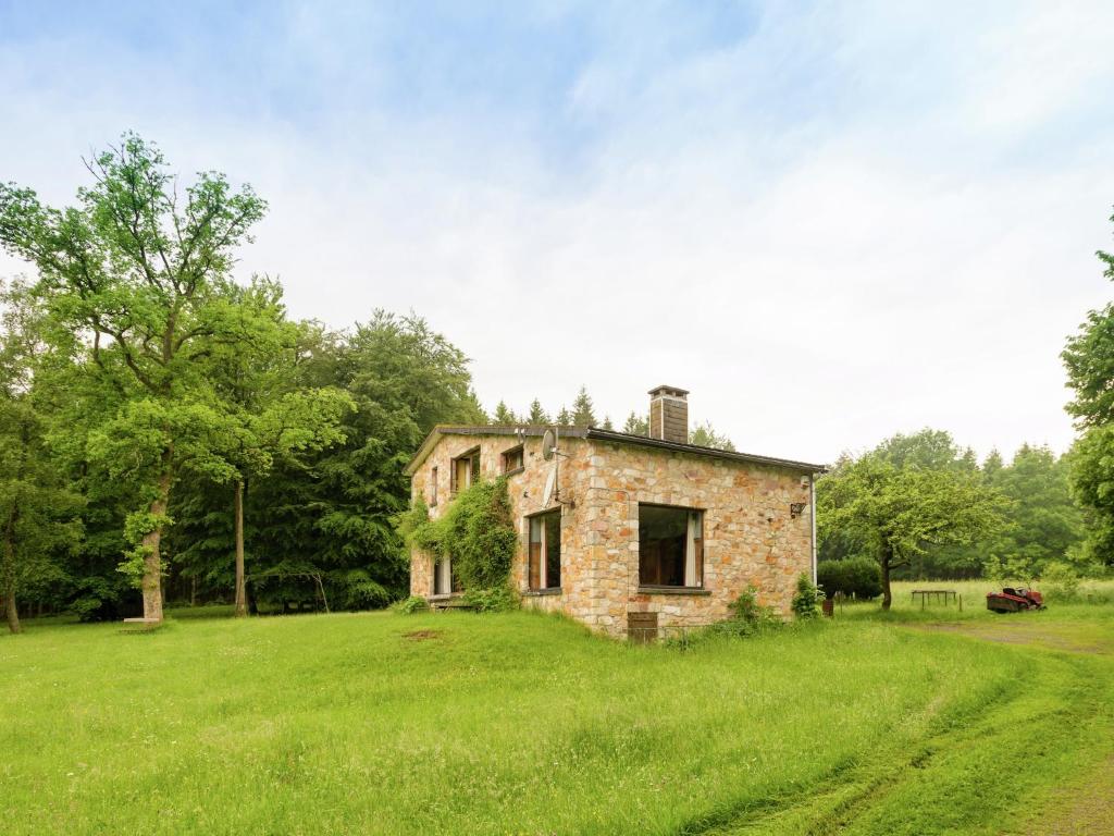 an old stone house in a field of grass at Rustic Retreat in Houvegné in Houvegné