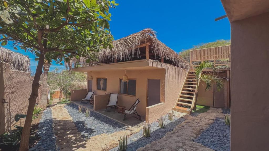 uma vista exterior de uma casa com uma árvore em Kinti Coliving Mancora em Máncora