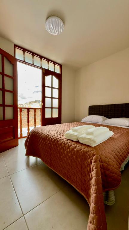 a bedroom with a bed with two pillows on it at Habitación con Balcón Castellares La Puebla in Ayacucho