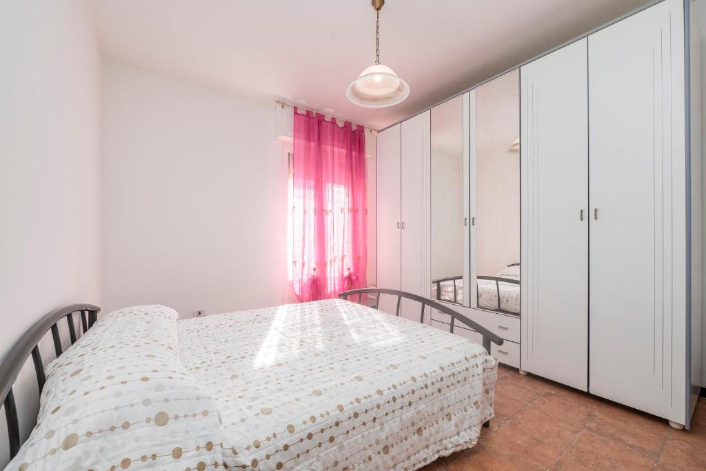 a bedroom with a bed and a pink curtain at 325 - Casa Pede a Deiva Marina - 300metri dalla Spiaggia e dal Mare e dal Centro Storico in Deiva Marina