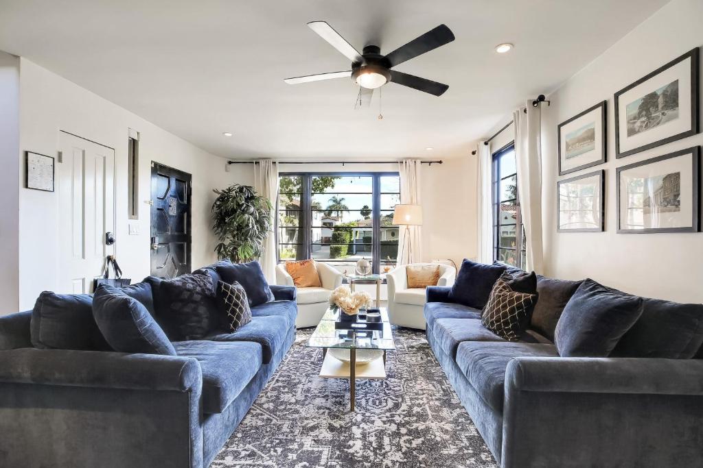 een woonkamer met blauwe banken en een plafondventilator bij West Beach Villa 4 in Santa Barbara