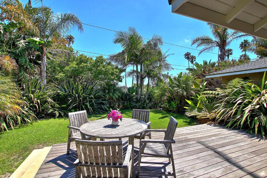 a wooden table and chairs on a deck at Little Palm Cottage in Santa Barbara
