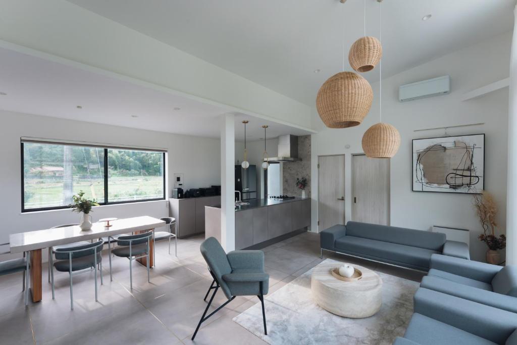 ein Wohnzimmer mit einer Couch und einem Tisch und Stühlen in der Unterkunft Laf Denen 千葉県富津市のvacation rental in Futtsu