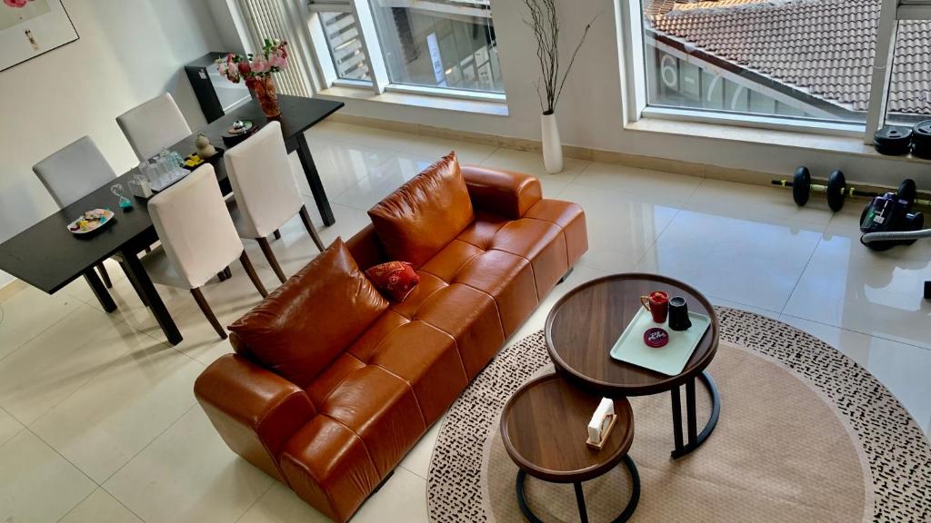 a living room with a brown leather couch and tables at Beijing city center- Duplex family flat with 3 bedrooms in Beijing
