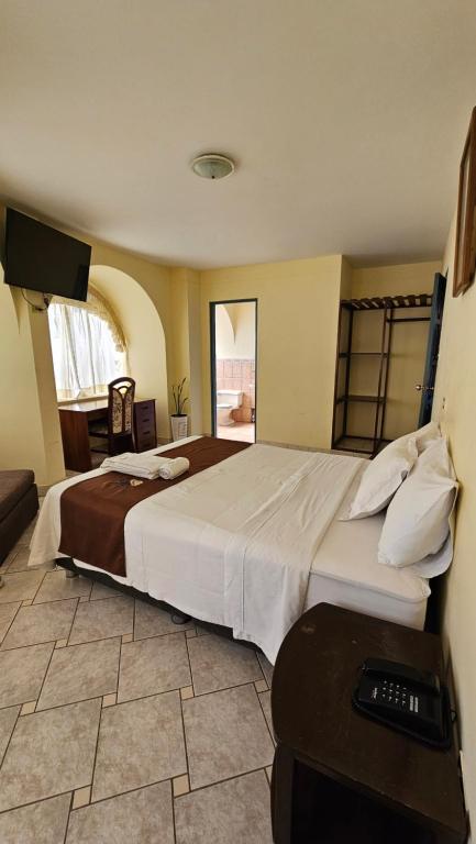 une chambre avec un grand lit dans une pièce dans l'établissement Hotel Bombonaje, à Rioja