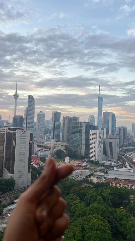 ręka wskazuje na panoramę miasta w obiekcie Dans Homestay Heaven w Kuala Lumpur