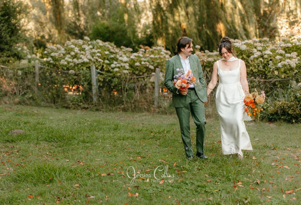 une mariée et un marié marchant dans l'herbe dans l'établissement Inn on the Russian River, à Monte Rio