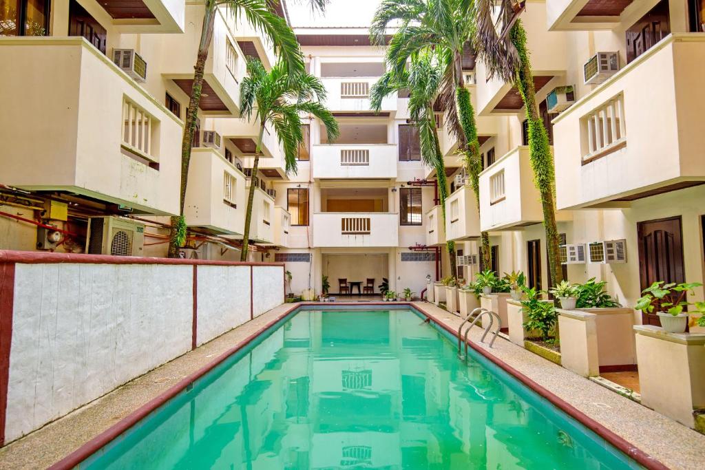 a swimming pool in an apartment building with palm trees at Palette Boracay Isle by The White Beach in Boracay