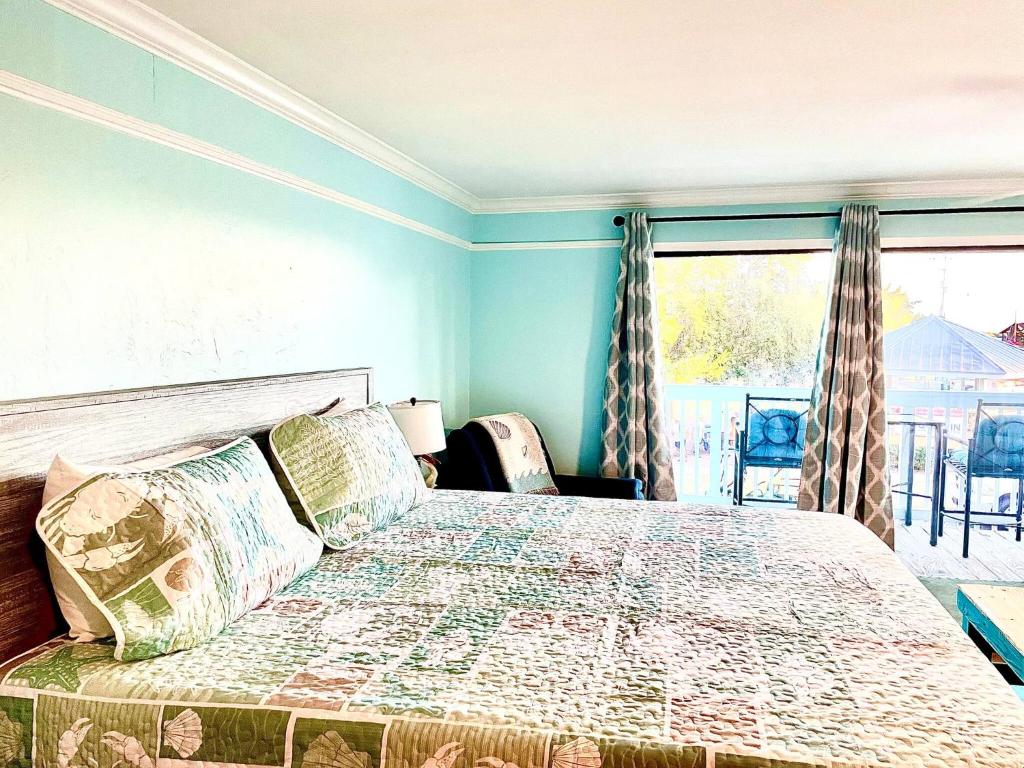 a bedroom with a bed with a view of a balcony at Cedar Key Islands Dolphins Cay Condo in Cedar Key
