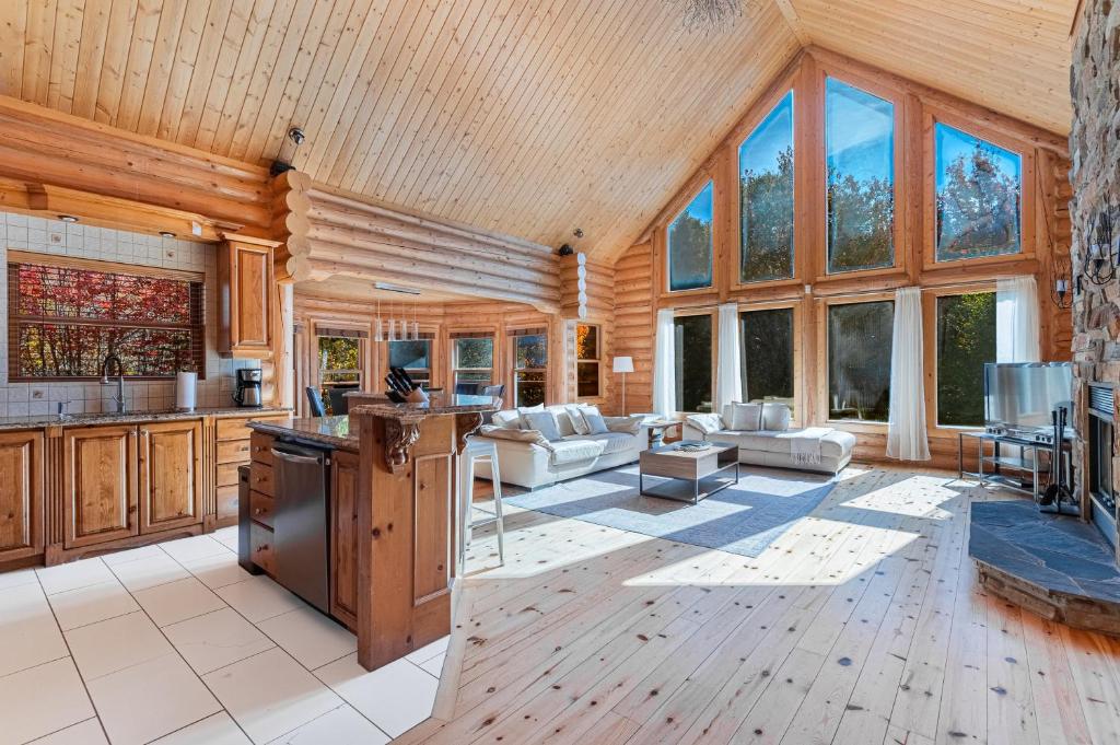 a kitchen and living room with wooden ceilings and windows at Fiddler Lake Resort - Deer 59 in Mille-Isles