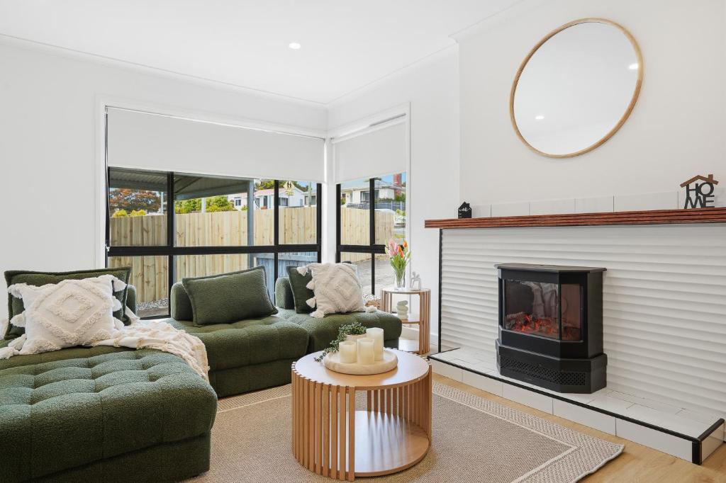 WarraneHobart Family Home near Airport & City的有两张沙发和一个壁炉的客厅