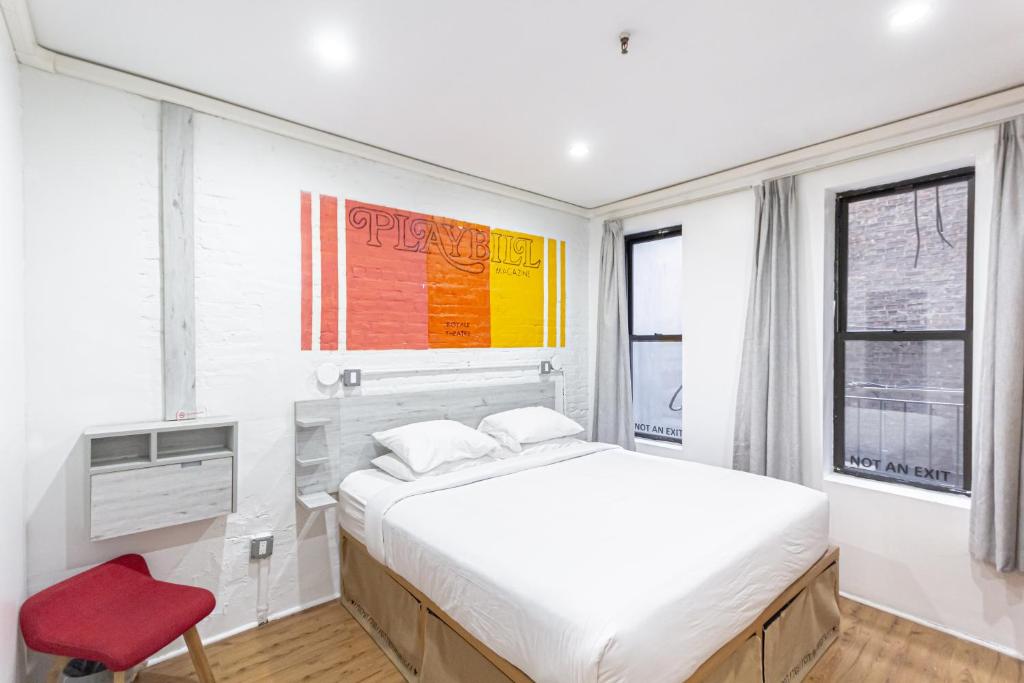 a bedroom with a bed and a red chair at JGSTAY - Times Square in New York