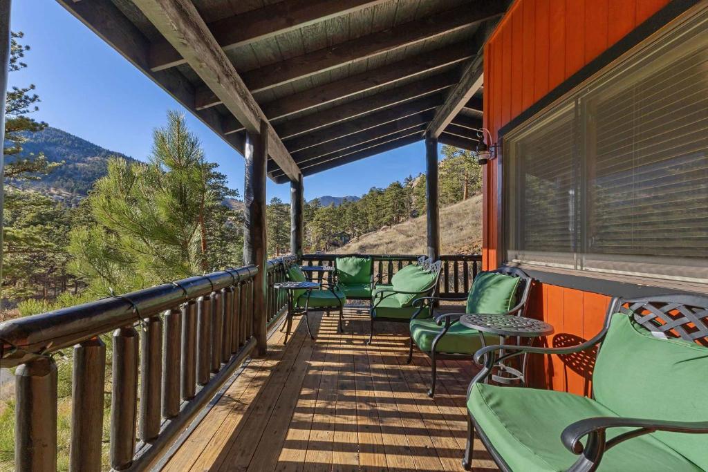 Eine Terrasse mit grünen Stühlen und Blick auf die Berge in der Unterkunft Cabin 9- Spacious cabin- 4 King beds- 2 baths in Estes Park