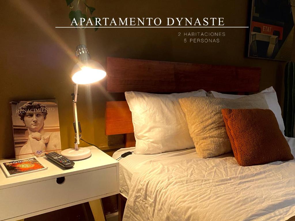 een slaapkamer met een bed en een tafel met een lamp bij Botanique Concept House Guanajuato Centro in Guanajuato