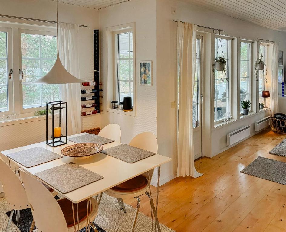 una sala da pranzo con tavolo, sedie e finestre di House With Forest And Beachside Location In Åhus ad Åhus