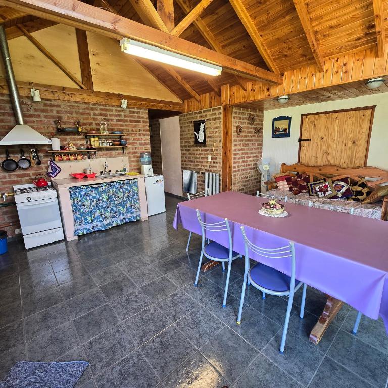 a large kitchen with a purple table and chairs at Casa Grande Trayken in El Hoyo