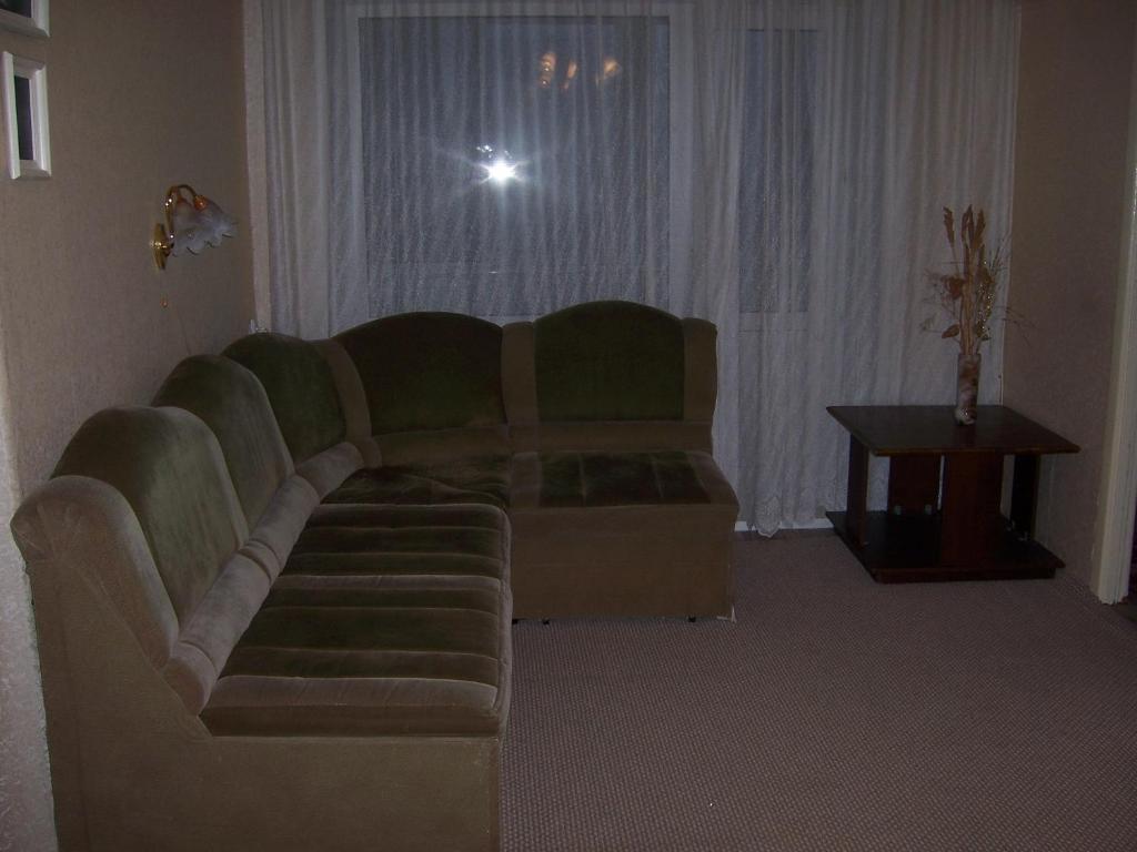 Apartments on Titova 2 في ياروسلافل: غرفة معيشة مع أريكة وطاولة