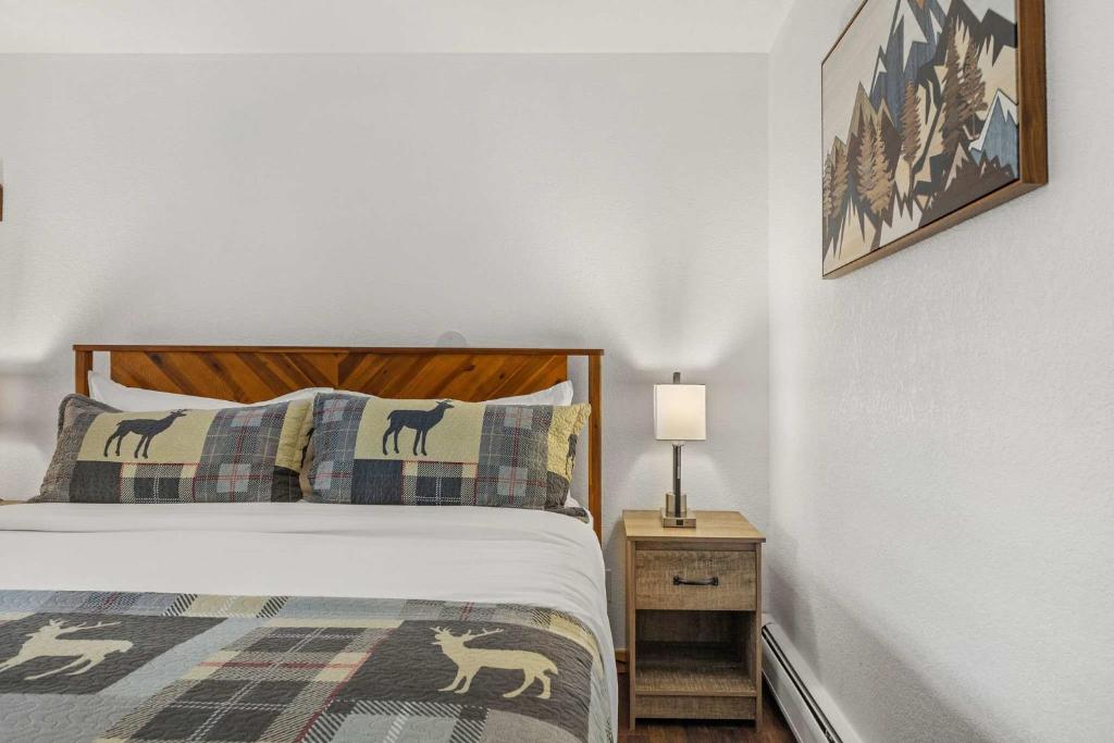 een slaapkamer met een bed en een lamp op een nachtkastje bij Cabin 17 - King Bed New Kitchen & Bath in Estes Park