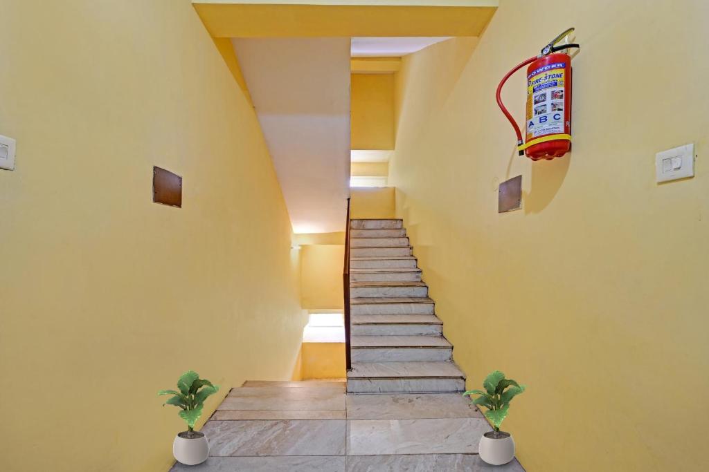 un escalier dans une maison aux murs jaunes dans l'établissement Hotel O Coastal Inn Luxury Service Apartments, à Kakinada