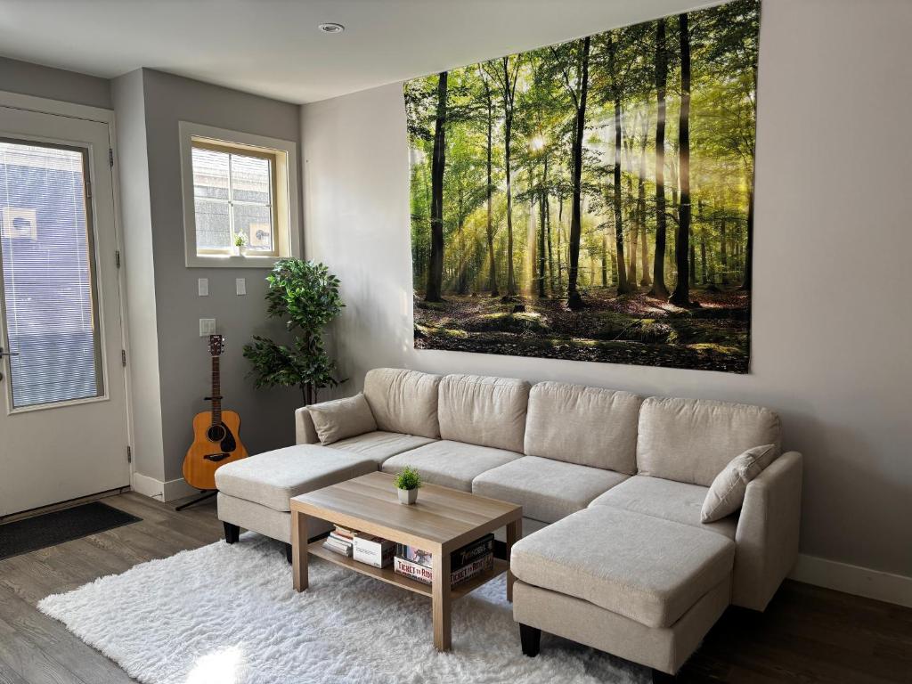 a living room with a couch and a painting on the wall at Nature Home Near Downtown and 17th Avenue in Calgary