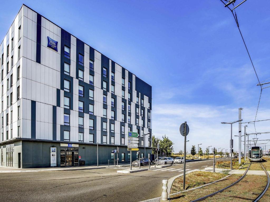 un grand bâtiment au bord d'une rue dans l'établissement ibis budget Paris Coeur d'Orly Airport, à Orly