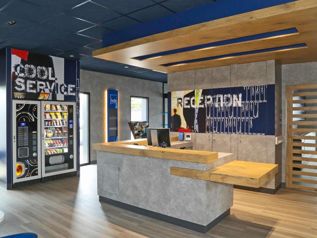 a food service counter in a restaurant with a refrigerator at Ibis Budget Amiens Centre Gare in Amiens