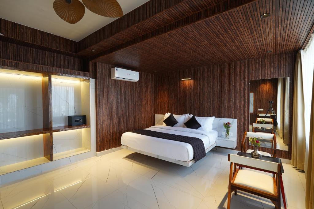 a bedroom with a white bed and a wooden wall at Shakuntalam Hotels in Udaipur