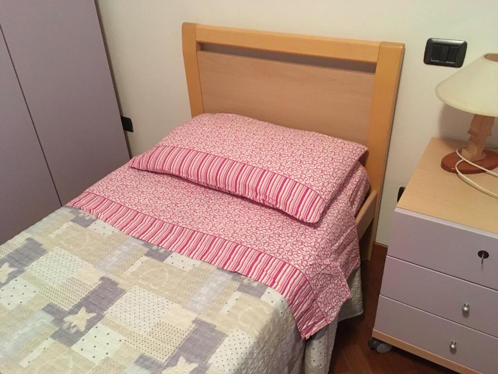 a small bedroom with a bed with a pink blanket at Mia in Marina di Massa
