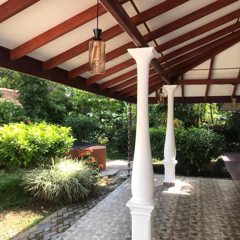 a pergola with white columns and a ceiling at T N D House in Habaraduwa Central