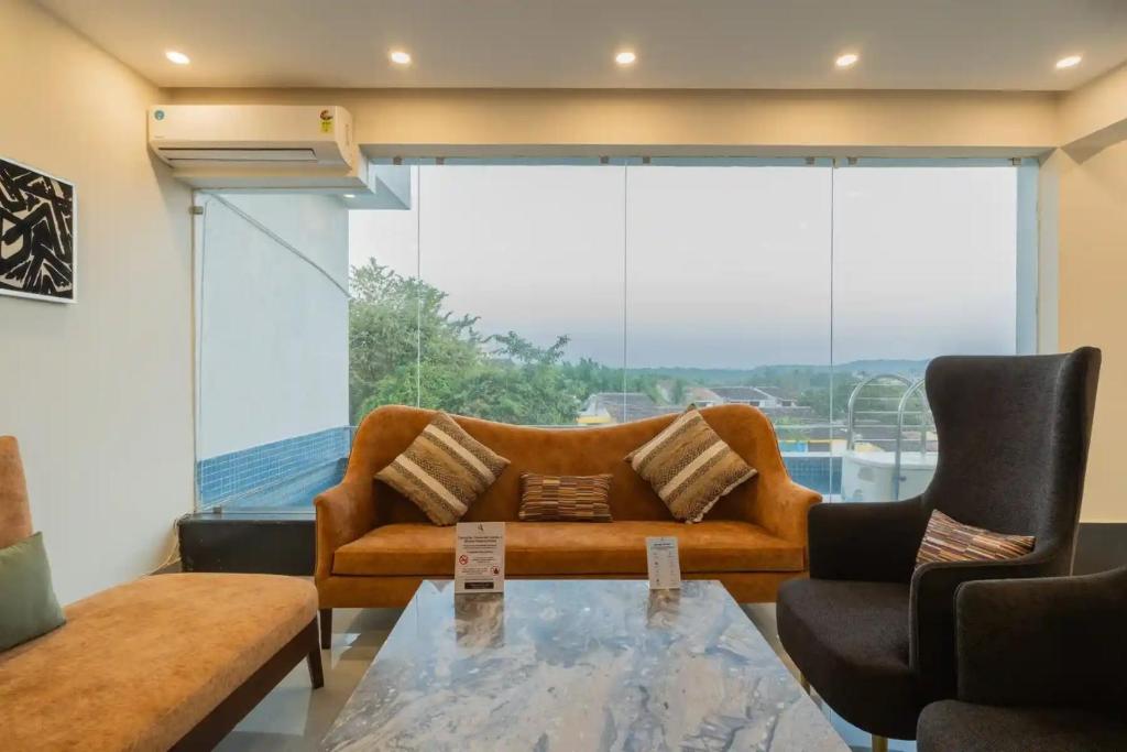 Una sala de estar con un sofá y una mesa de cristal. en Luxury Apartments Candolim Luxfort, en Candolim