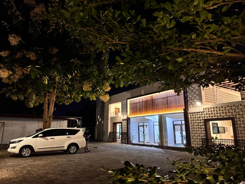 a white car parked outside of a building at night at El Bakatir in Banyuwangi