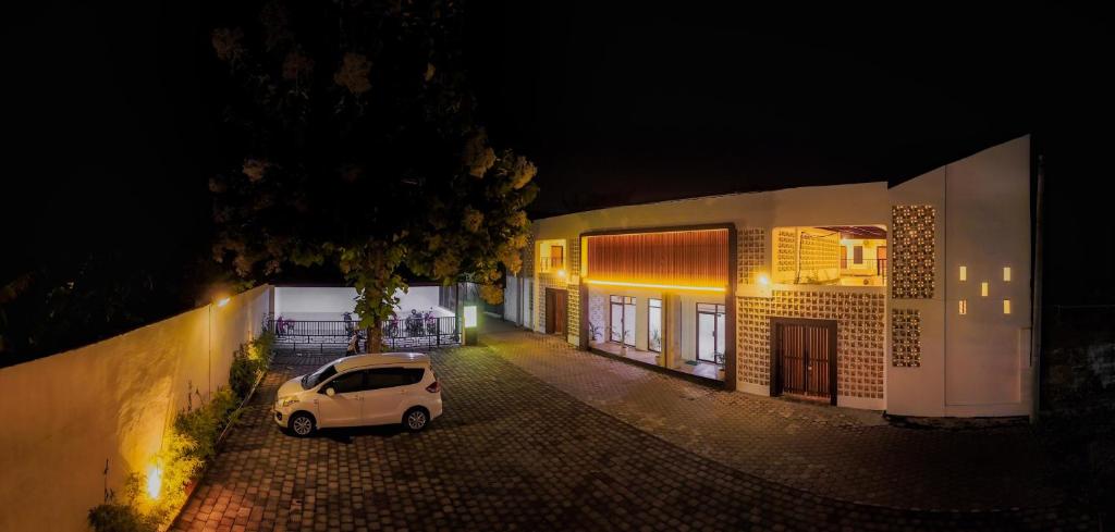 una piccola auto parcheggiata di fronte a un edificio di notte di El Bakatir a Banyuwangi