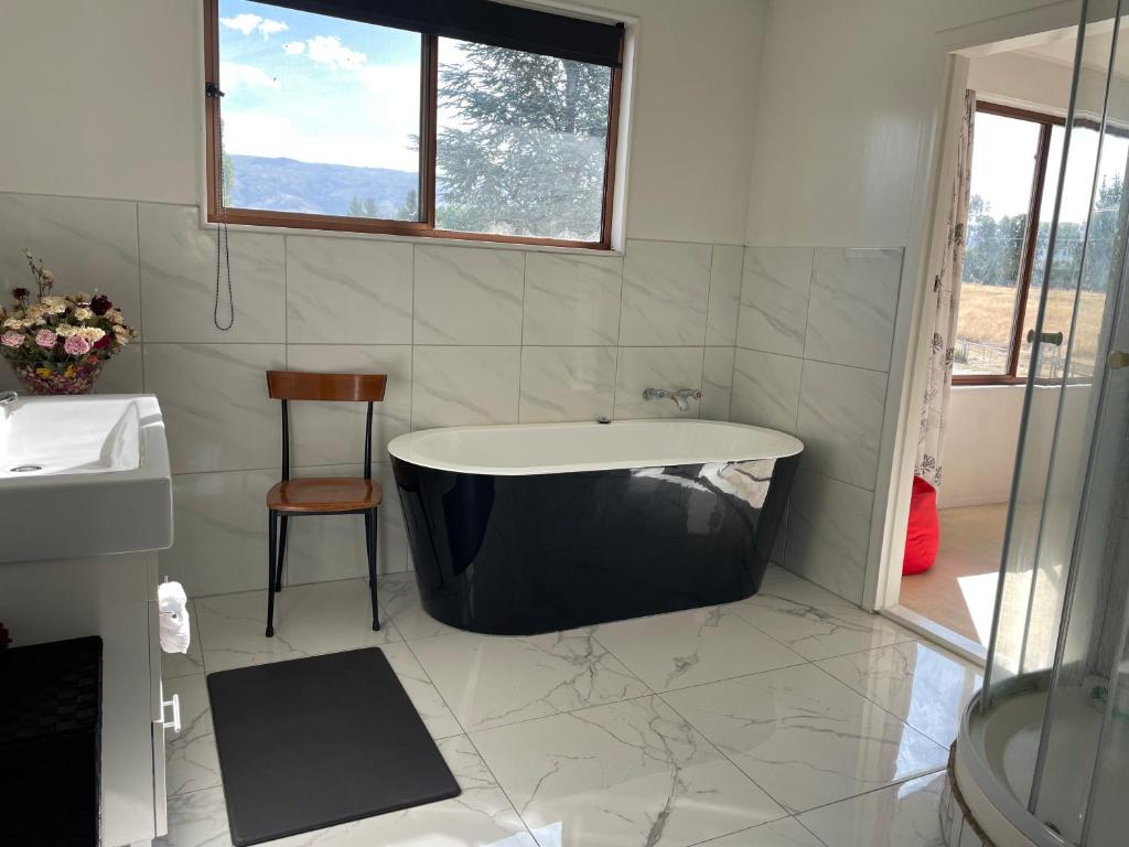 亚历山德拉Central Otago Farmlet的带窗户的浴室里的浴缸