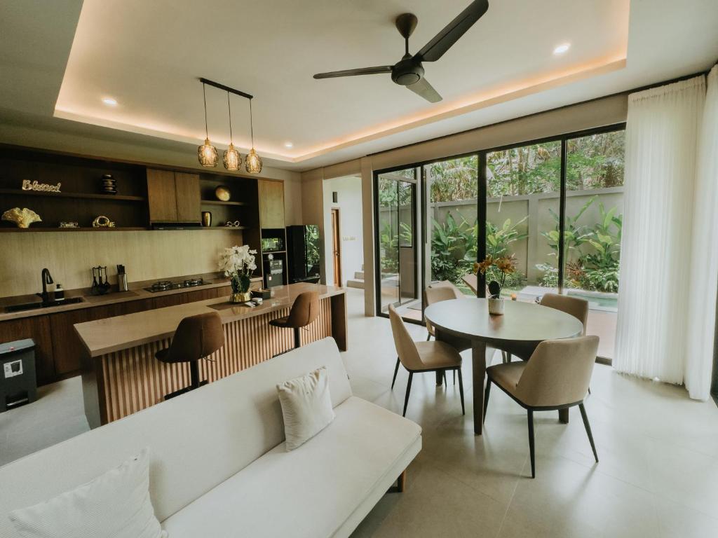 a living room with a white couch and a table at Nusari Villa Ubud in Ubud