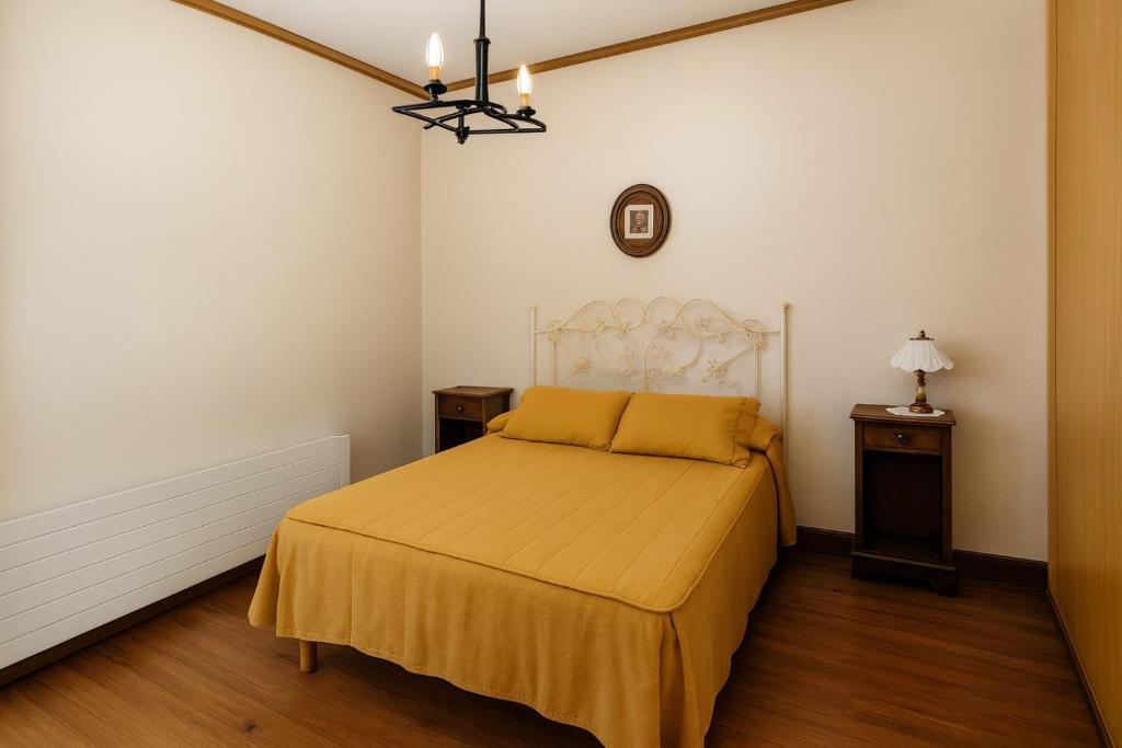 a bedroom with a bed with a yellow bedspread at Hotel HALLEY & Vive la Magia del Valle de Elqui in Vicuña