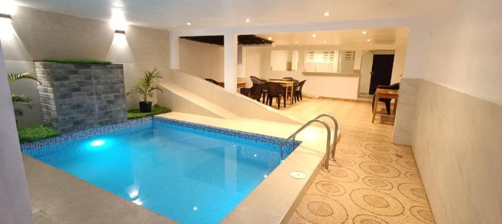 a large swimming pool in a living room with a dining room at Hostal Maravilla Amazónica in Iquitos