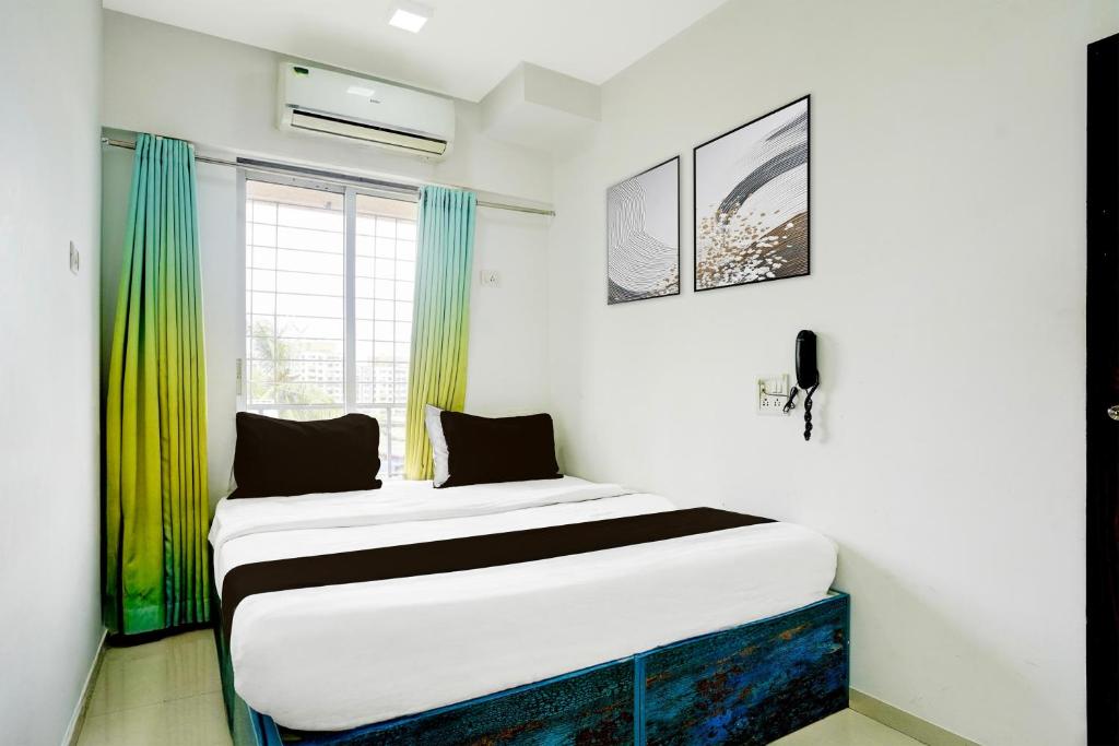 Cama en habitación con cortinas verdes en Collection O Viviana Mall Thane West Formerly Athithi Stays, en Thane