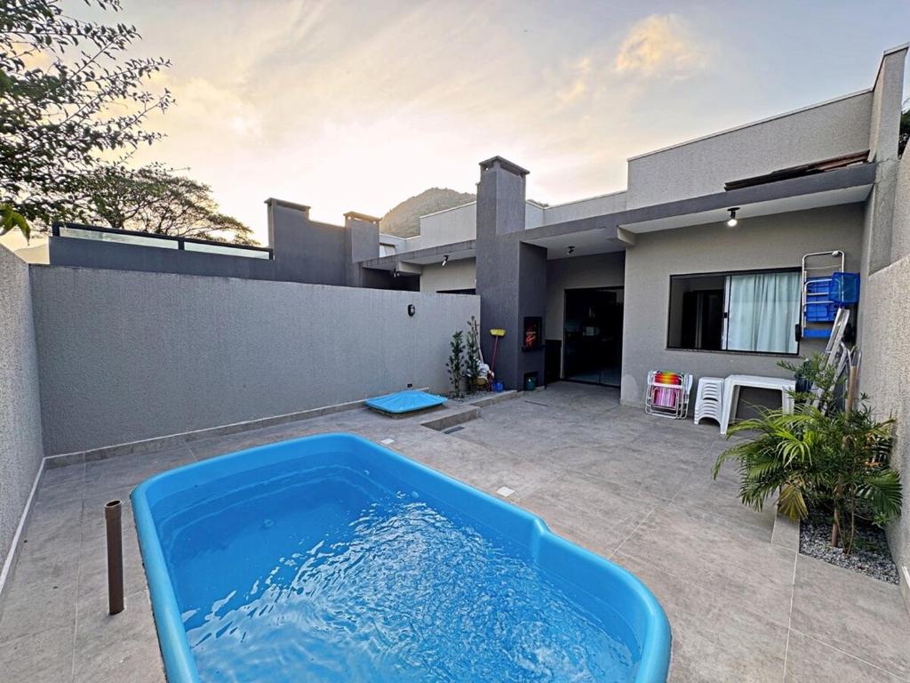 Una gran bañera azul frente a una casa. en Casa aconchegante piscina, en Matinhos