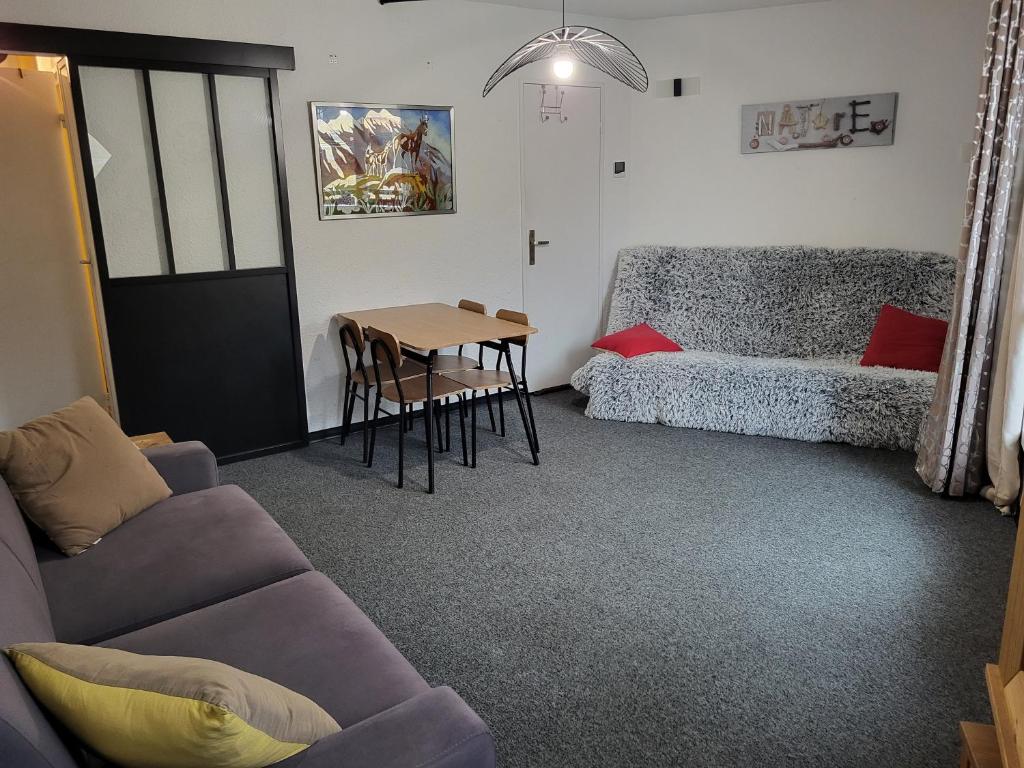 una sala de estar con un sofá y una mesa en Studio Le Boussolenc, en Les Orres