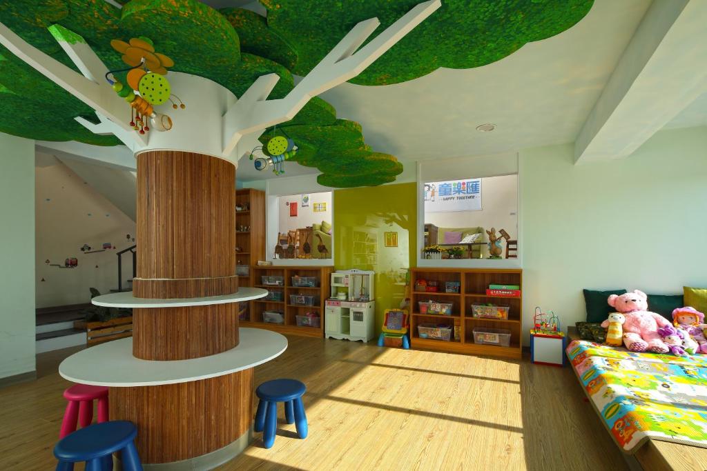 une chambre pour enfants avec une fresque murale sur les arbres au plafond dans l'établissement Happy Together B&B, à Wujie