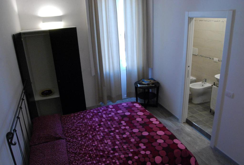 1 dormitorio con 1 cama con sábanas moradas y baño en Guest House Zefiro, en Florencia