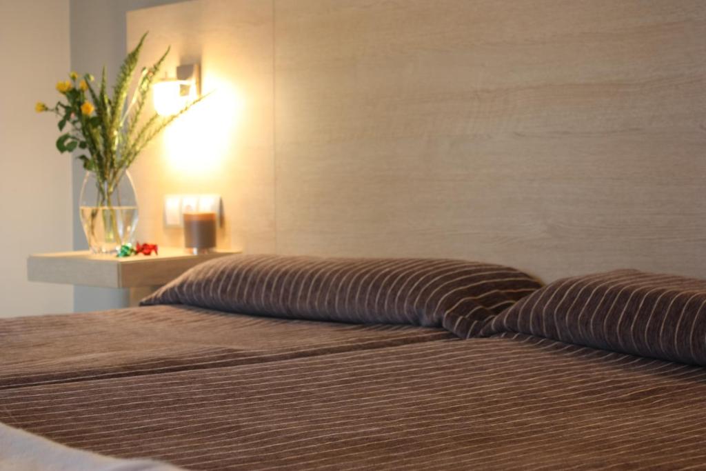 sypialnia z 2 łóżkami i wazonem z kwiatami w obiekcie Hotel Pontes do Eume w mieście Puentes de García Rodríguez